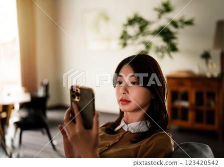 Upper body of a woman looking at a smartphone 123420542