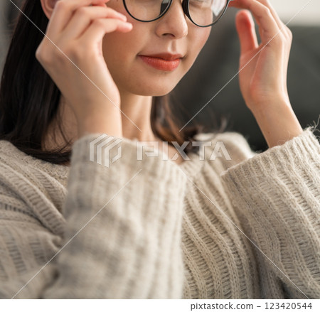 Woman's hands fixing glasses 123420544