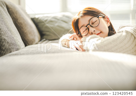 戴眼鏡的女人在沙發上放鬆 123420545