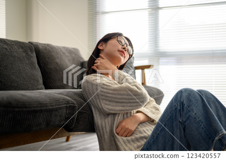 戴眼鏡的女人摸著脖子 戴眼鏡的女人摸著脖子 123420557