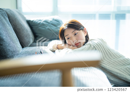 坐在窗邊沙發上沉思的女人 123420567