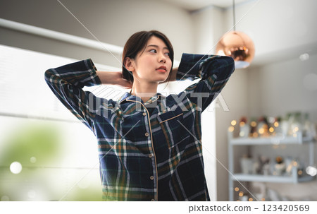 Woman in pajamas fixing her hair 123420569