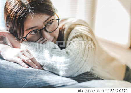 A woman relaxing on a sofa in the sunshine 123420571