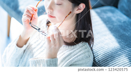 一位女士摘下眼鏡的側面照 123420575