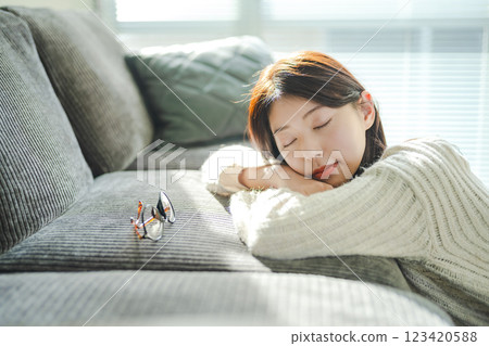 A woman sleeping on a sofa with her glasses removed A woman sleeping on a sofa with her glasses removed 123420588