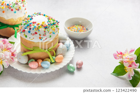 Easter cakes decorated with colorful sprinkles and chocolate eggs on festive table 123422490