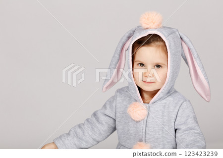 Adorable Toddler in Bunny Costume Smiling on White Grey Background 123423239