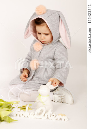 Thoughtful Toddler in Bunny Costume Looking Serious on White Grey Background 123423241