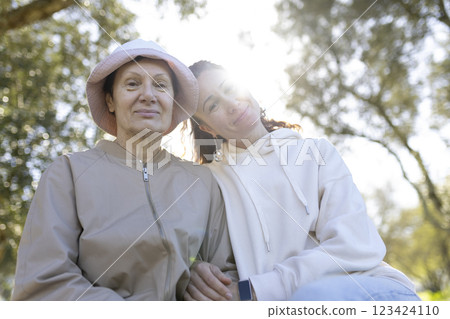 Senior woman and daughter enjoying time together in park on sunny day 123424110