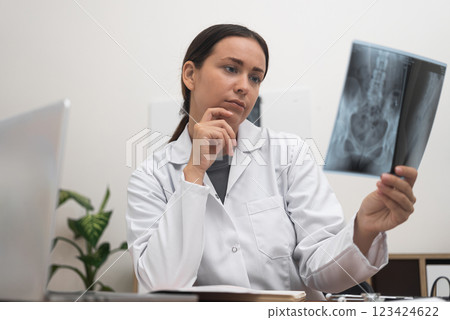 Medical Examination: Within the framework of healthcare services, a doctor examines the patient's illness using a radiological X-ray film for a precise diagnosis.  123424622