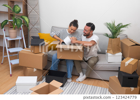 moving day is palpable as a young couple unpacks on the sofa in their new home, highlighting the concepts of relocation and the real estate experience 123424779
