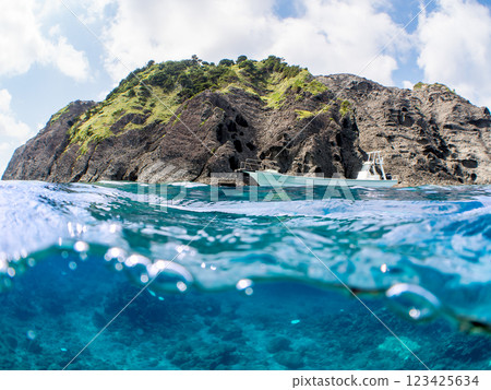 Beautiful half-surface shot of a Hirizohama fishing boat, viewed from safe waters, with divers on board. 123425634