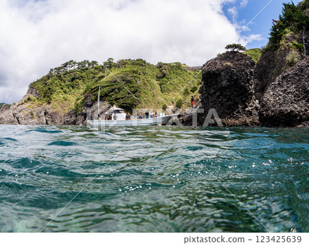 Beautiful half-surface shot of a Hirizohama fishing boat, viewed from safe waters, with divers on board. 123425639