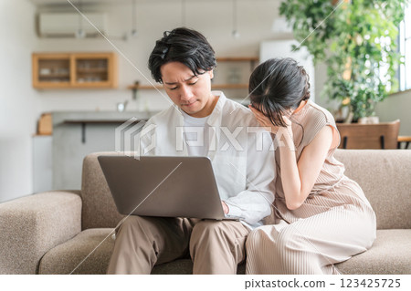 Couple shocked while looking at a computer (fraud, investment, failure, being deceived) 123425725