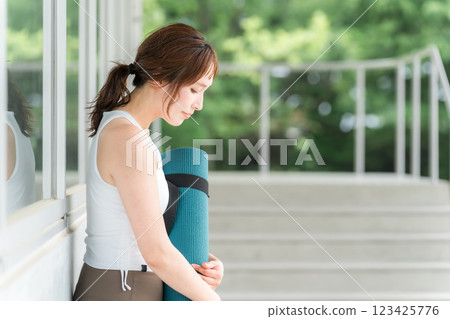 Healthy woman holding a yoga mat (yoga instructor/yogini) 123425776