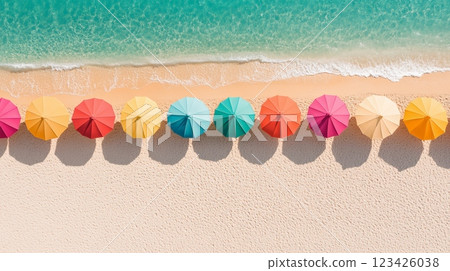 Aerial view captures a vibrant row of colorful beach umbrellas on a pristine sandy beach, with the gentle waves of turquoise water lapping at the shore, creating a perfect summer holiday scene 123426038