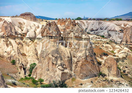 Unique rock formations rise majestically in the Cappadocia landscape under a clear blue sky 123426432