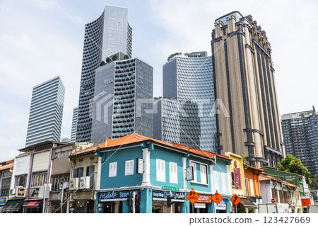 Street view of the traditional shophouses with a skyscraper background in Kampong Glam, Singapore, there are many exotic Middle Eastern restaurants, and homeware shops here. 123427669