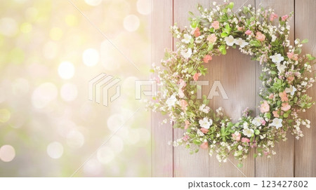 Beautiful eco-friendly wreath of fresh flowers welcomes spring on a wooden door, surrounded by warm light 123427802
