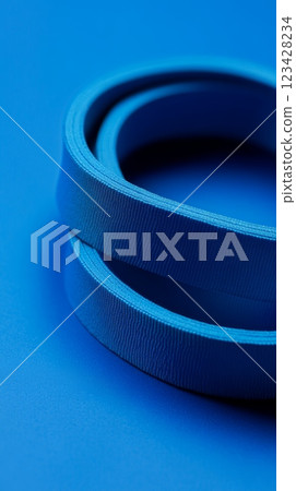 Two grosgrain ribbons forming concentric circles on a blue background create an interesting abstract composition, perfect for backgrounds and design projects 123428234