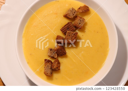 Indulge in a bowl of Creamy Pumpkin Soup garnished with crunchy Croutons, deliciously made Indulge in a bowl of Creamy Pumpkin Soup garnished with crunchy Croutons, deliciously made 123428550
