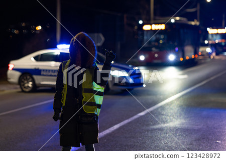 Protester with police cars in the background at night 123428972