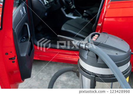Vacuum cleaner next to the car. Interior dry cleaning 123428998