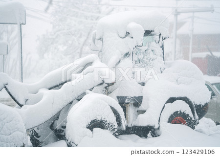 Snow blower stuck in snowdrift 123429106