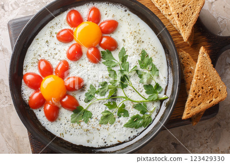 Flower fried eggs with cherry tomatoes and parsley close-up on plate. Funny food. Horizontal top view Flower fried eggs with cherry tomatoes and parsley close-up on plate. Funny food. Horizontal top view 123429330