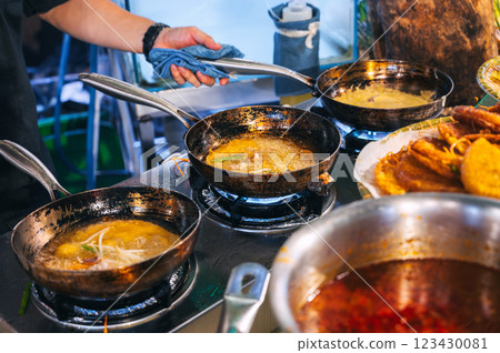 male chef cooks in kitchen of a restaurant. Cook's hands with a frying pan at the stove 123430081