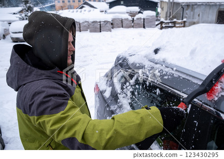 Person Clearing Snow from Car in Winter Landscape Person Clearing Snow from Car in Winter Landscape 123430295