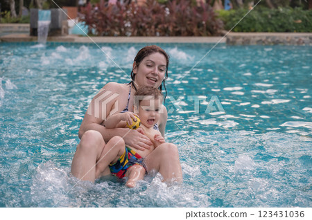 A Caucasian woman and her one-year-old son swim in a pool. 123431036