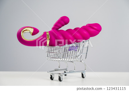 Sex toy in miniature shopping cart on white background. Sex toy in miniature shopping cart on white background. 123431115