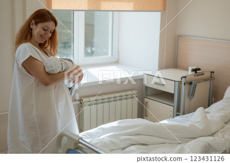 Caucasian woman holding newborn son in maternity hospital ward. Caucasian woman holding newborn son in maternity hospital ward. 123431126