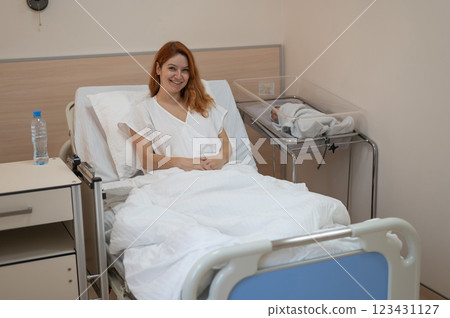 Happy young mother in the maternity hospital ward with her newborn son. Happy young mother in the maternity hospital ward with her newborn son. 123431127