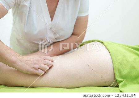Anti-cellulite manual massage of thighs. Anti-cellulite manual massage of thighs. 123431194