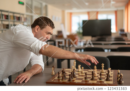 Caucasian man thinking about a chess move.  123431383