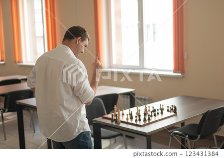 Caucasian man thinking about a chess move. Caucasian man thinking about a chess move. 123431384