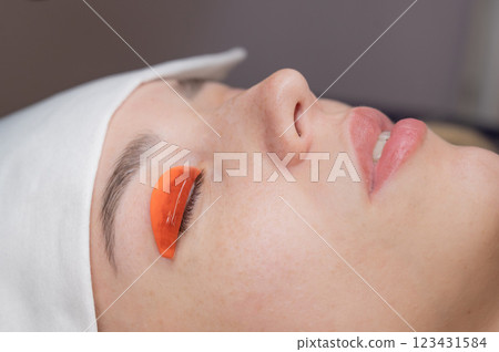Caucasian woman undergoing eyelash lamination procedure.  123431584