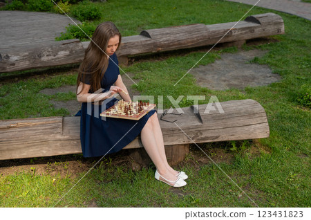 Caucasian woman playing chess outdoors. Caucasian woman playing chess outdoors. 123431823
