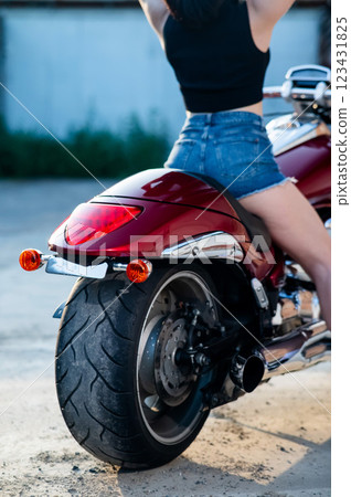 Close up of woman's buttocks in shorts sitting on motorcycle. Close up of woman's buttocks in shorts sitting on motorcycle. 123431825