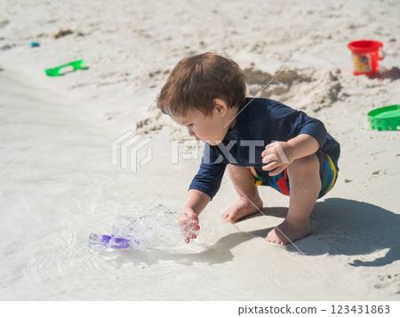 One year old Caucasian boy plays in the sand on the seashore. One year old Caucasian boy plays in the sand on the seashore. 123431863
