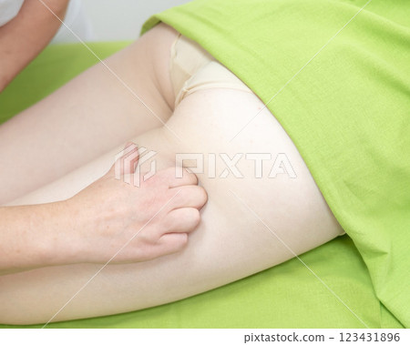 Anti-cellulite manual massage of thighs.  123431896