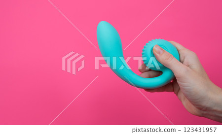 Woman holding blue curved sex toy on pink background. Copy space. Woman holding blue curved sex toy on pink background. Copy space. 123431957