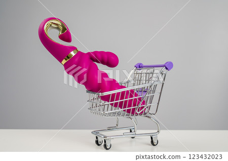Sex toy in miniature shopping cart on white background. Sex toy in miniature shopping cart on white background. 123432023