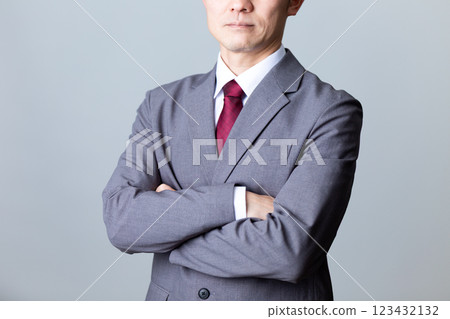 一位身穿灰色西裝、交叉雙臂的中年男性商人 123432132