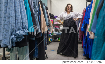 A fat woman chooses clothes in a plus size store. A fat woman chooses clothes in a plus size store. 123432282