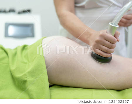 Caucasian woman on hardware anti-cellulite massage. Thigh cavitation procedure. Caucasian woman on hardware anti-cellulite massage. Thigh cavitation procedure. 123432367