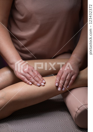 Close-up of a woman's leg massage in a salon. Vertical photo. 123432372