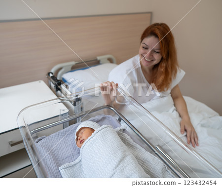 A young mother admires her newborn son in the maternity hospital.  123432454